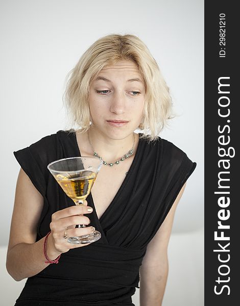 Blonde Young Woman With Beautiful Blue Eyes Drinks A Martini