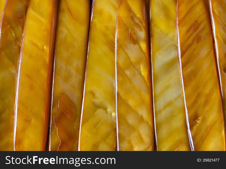 Closeup of a bracelet made with golden colour sea shells cut into lengths, polished and laid side by side. Closeup of a bracelet made with golden colour sea shells cut into lengths, polished and laid side by side.