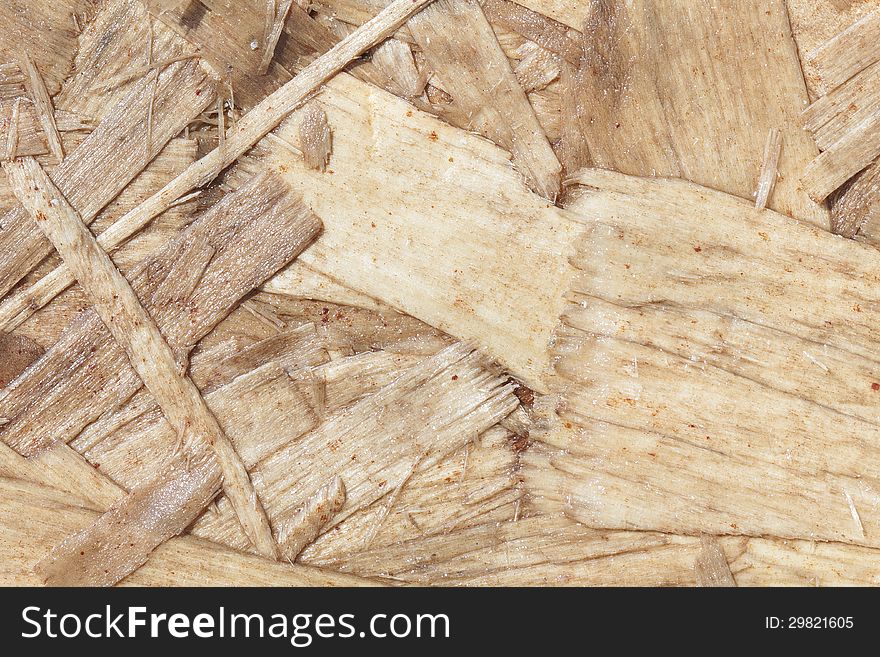 Closeup of a section of particle board clearly showing individual chips of wood and wood grain. Closeup of a section of particle board clearly showing individual chips of wood and wood grain.