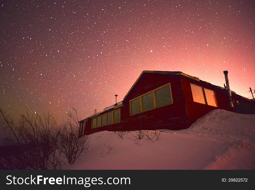 Photograph of a cottage with stars in the background. useful for showing living in cold countries. Photograph of a cottage with stars in the background. useful for showing living in cold countries