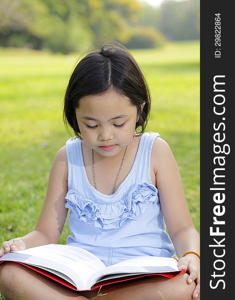 Asian little girl reading book