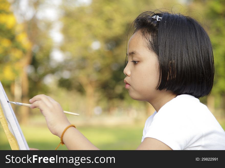 Asian little girl painting in the park. Asian little girl painting in the park