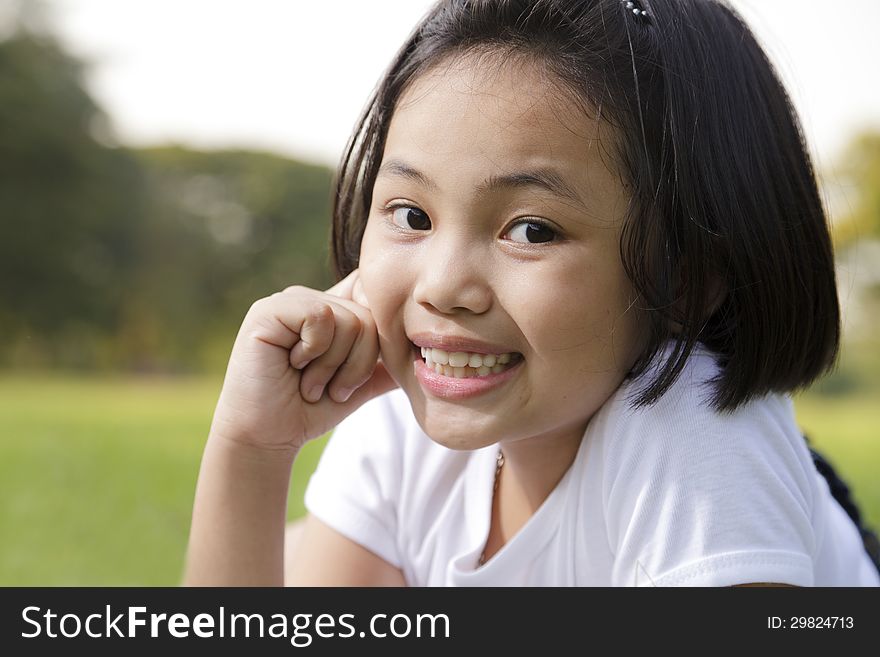 Asian little girl relax and smiling happily in the park