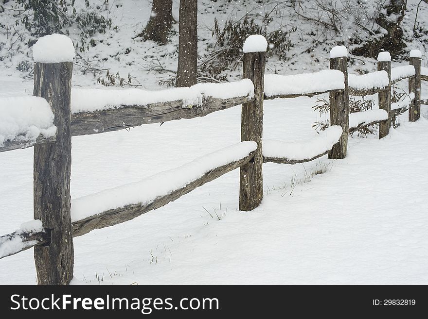 Snow covering a split rail fence.