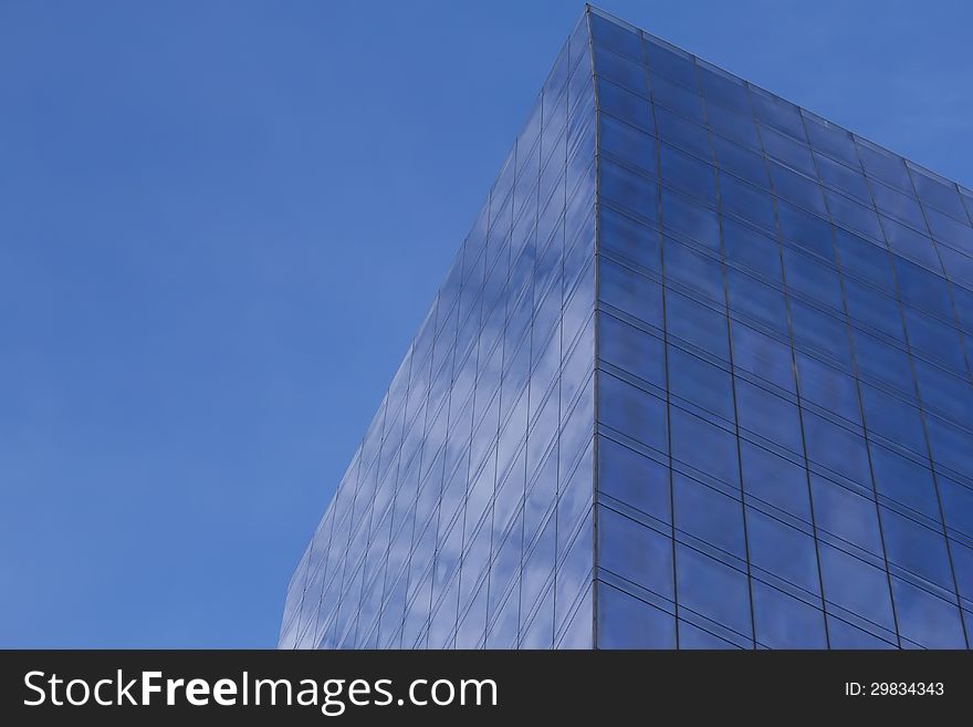 Modern business building with clouds reflection and blue sky in the byckground. Horizontally.