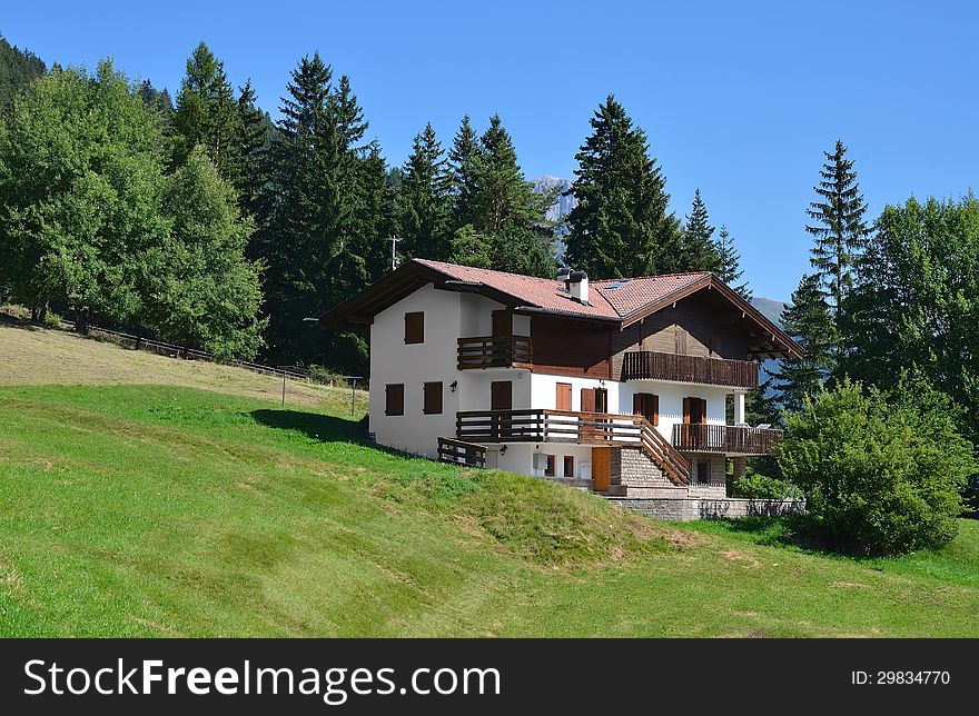 House in Alpine village. Sunny summer day. Dolomites, Val di Fassa, Italy. House in Alpine village. Sunny summer day. Dolomites, Val di Fassa, Italy.