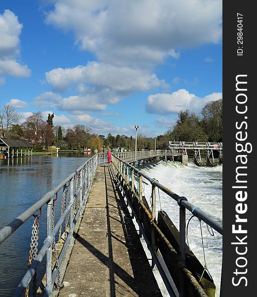 Flood water passing through a Weir and sluice gate on the River Thames in England