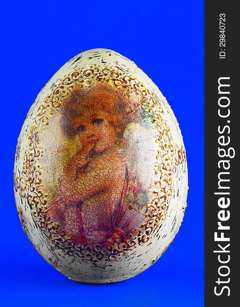 Easter egg with the image of an angel, close up, blue background