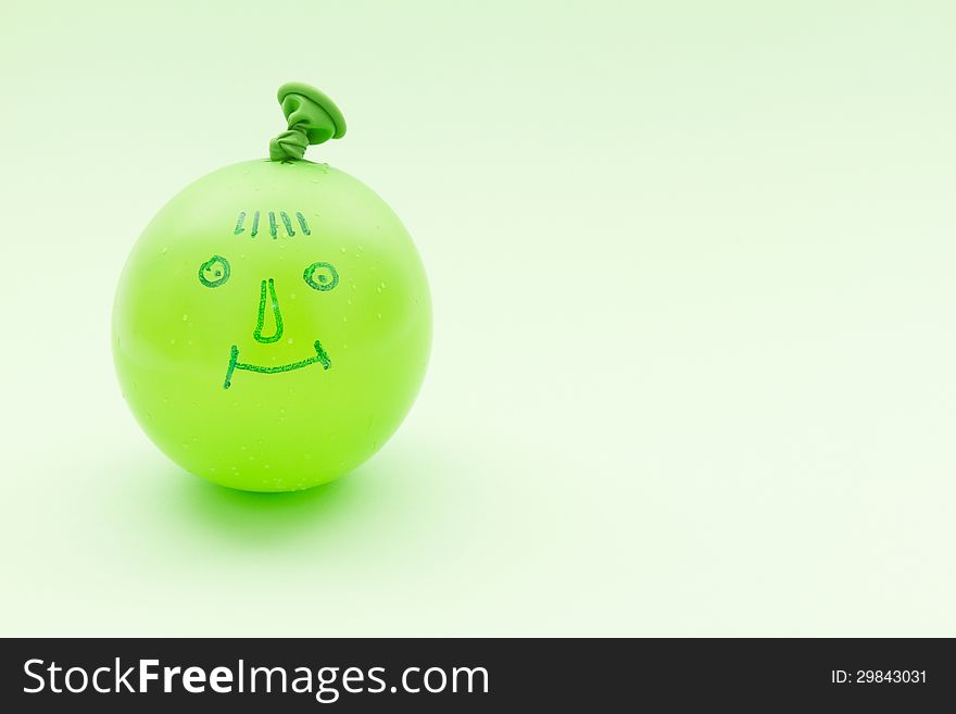 Drawing smile on inflated green baloon. Drawing smile on inflated green baloon