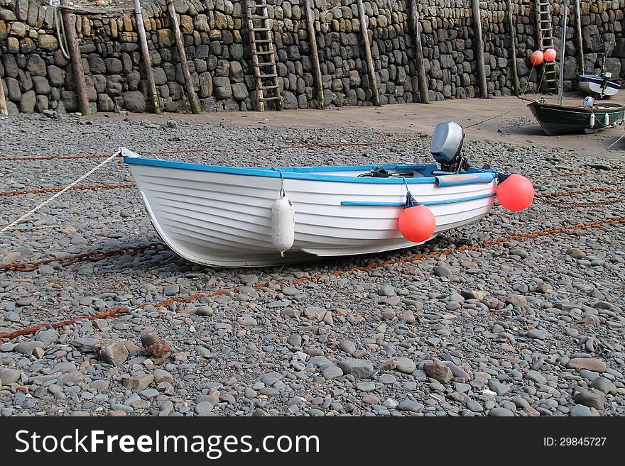 A Small Motor Boat Resting on a Dry Harbour Floor. A Small Motor Boat Resting on a Dry Harbour Floor.