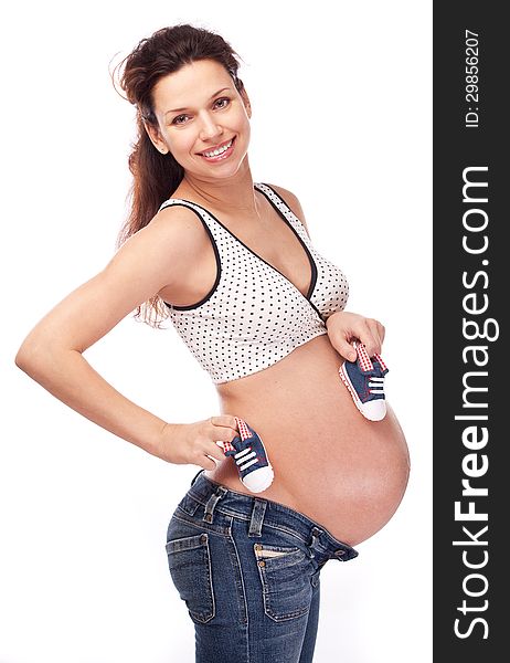 Pregnant woman caring small shoes over belly. On a white background. Pregnant woman caring small shoes over belly. On a white background.