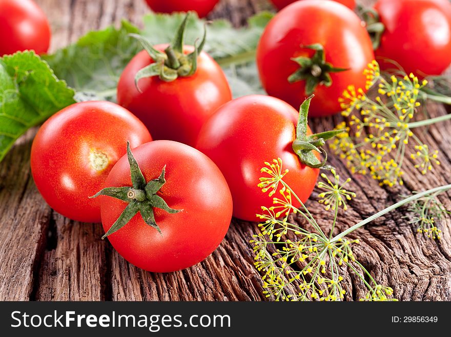 Tomatoes, cooked with herbs for the preservation on the old wooden table.