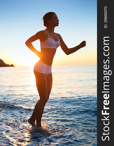 athletic woman running on the beach. athletic woman running on the beach.