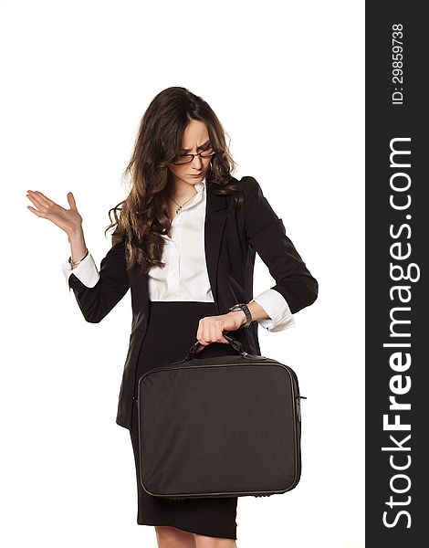 Worried business woman looking at the clock and holding the bag for laptop. Worried business woman looking at the clock and holding the bag for laptop