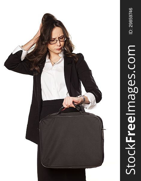 Worried business woman looking at the clock and holding the bag for laptop. Worried business woman looking at the clock and holding the bag for laptop