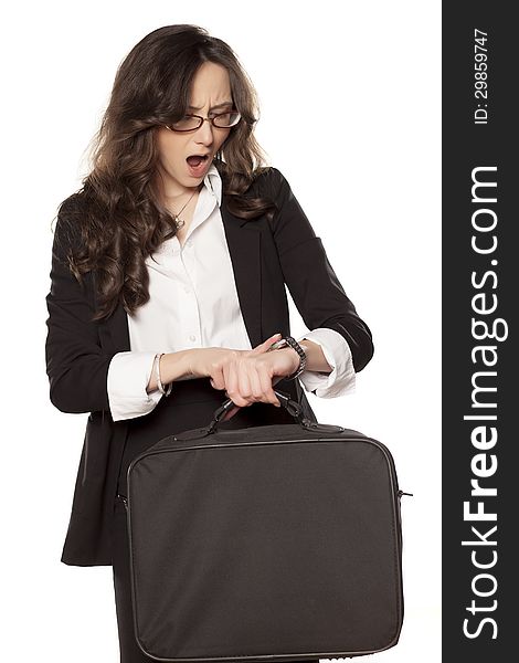 Worried business woman looking at the clock and holding the bag for laptop. Worried business woman looking at the clock and holding the bag for laptop