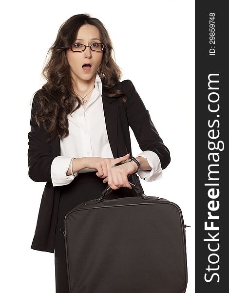 Worried business woman looking at the clock and holding the bag for laptop. Worried business woman looking at the clock and holding the bag for laptop