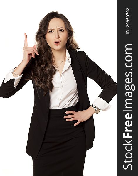 Frowning and angry business woman pointing a finger upwards