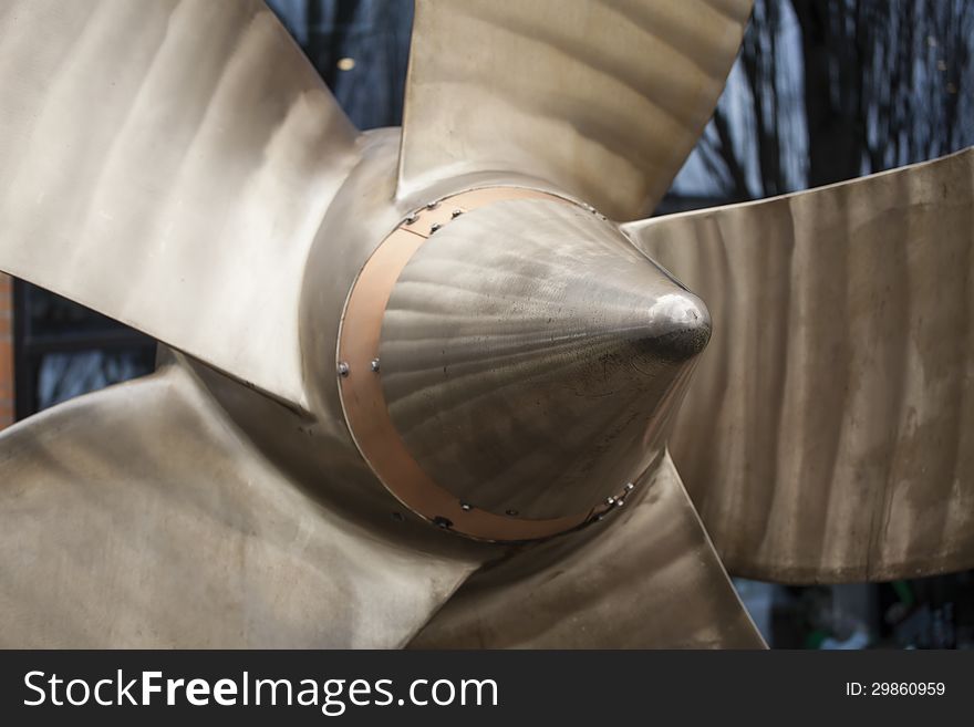 Large metallic propellor with blue background.