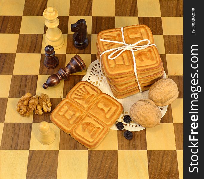 Yellow cookies with nuts on the chessboard. Yellow cookies with nuts on the chessboard