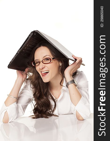 Smiling girl covers her head with a laptop on white background. Smiling girl covers her head with a laptop on white background