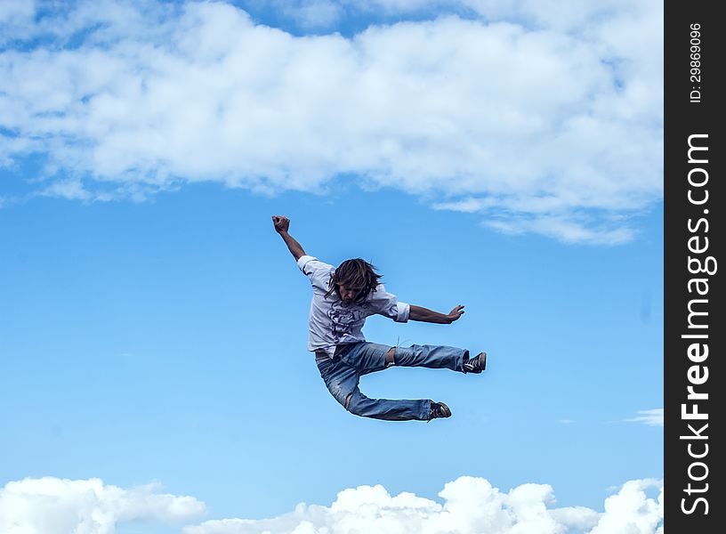 Guy jumps up against the sky with clouds. Guy jumps up against the sky with clouds