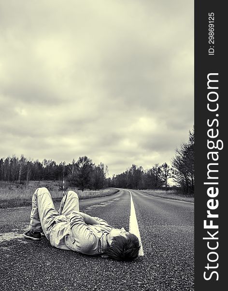 Young guy lies on the road