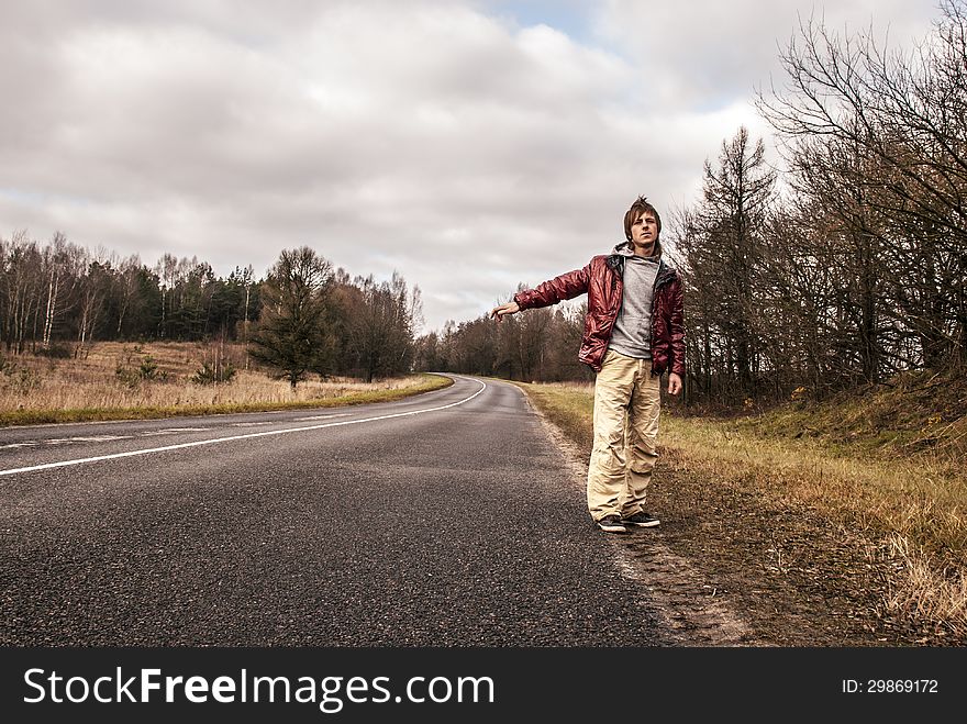 Man Hailing on a roadside of the forest road. Man Hailing on a roadside of the forest road