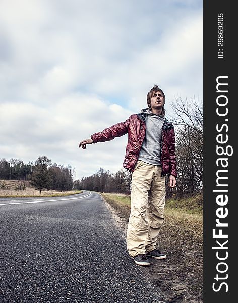 Man Hailing On A Roadside Of The Road