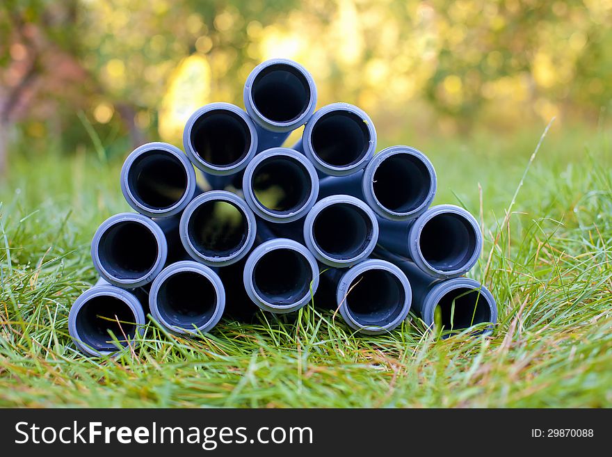 Pipes stacked on the grass in the garden. Pipes stacked on the grass in the garden