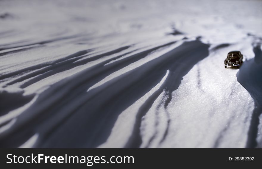 Little lonely black model of retro car on snow