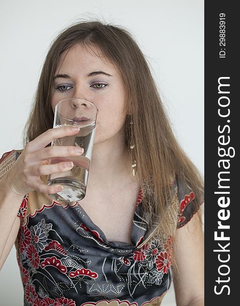 Young Woman with Beautiful Green Eyes Drinking Glass of Water