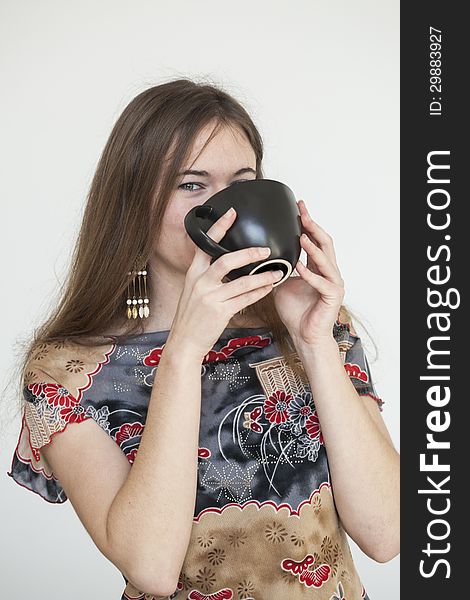 Portrait of a young woman with a black coffee cup looking directly at the camera. Portrait of a young woman with a black coffee cup looking directly at the camera