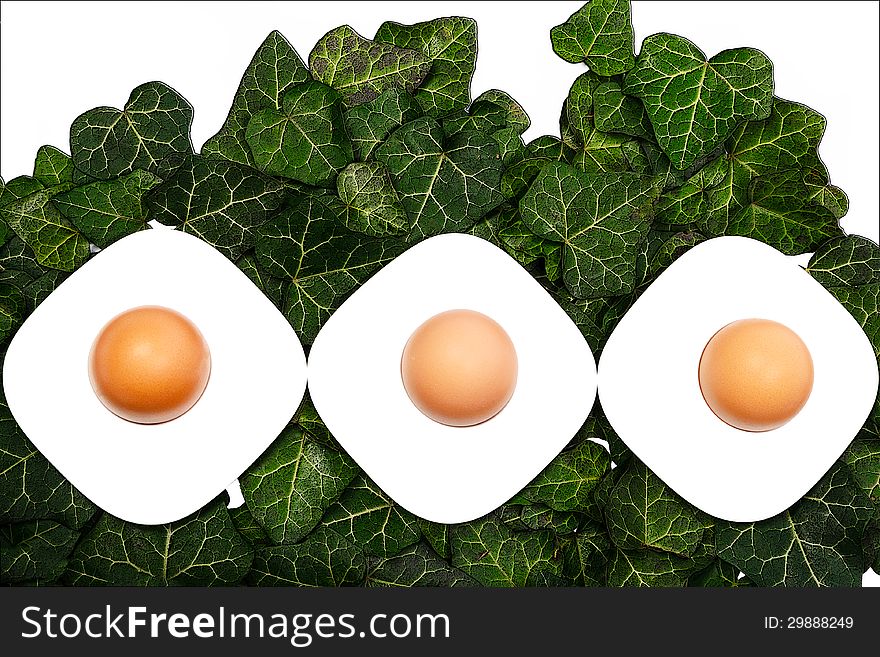 Three eggs and egg cups on a green background. Three eggs and egg cups on a green background