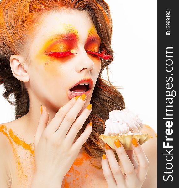 Gilding. Tempting Woman eating a Pie with Cream. Bright Red-Golden Makeup