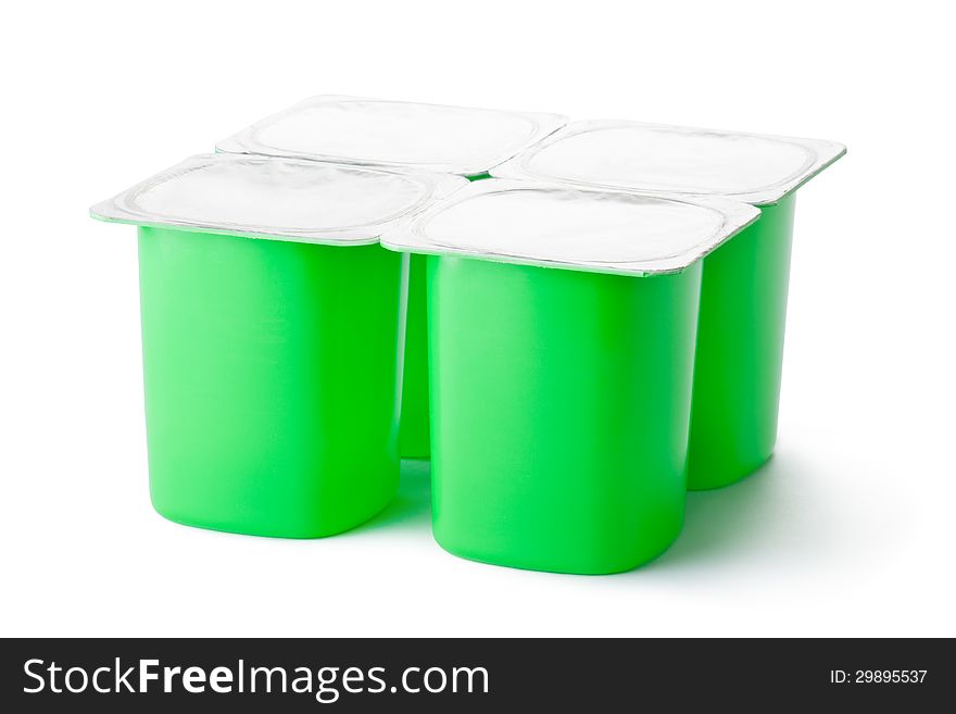 Four plastic containers for dairy products with foil lid. Standing on a white.