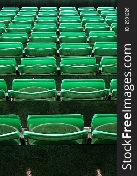 Many plastic green seats on football stadium. Many plastic green seats on football stadium