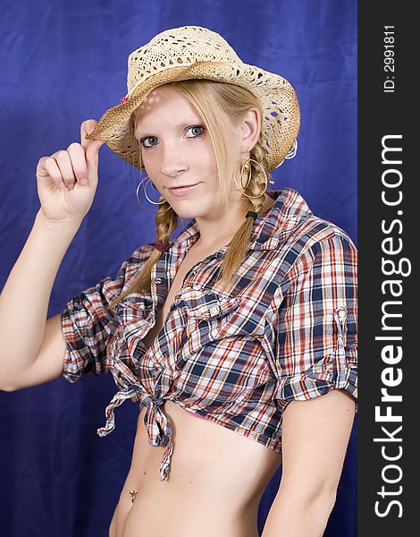 An attractive blond teen in check shirt and straw hat. An attractive blond teen in check shirt and straw hat