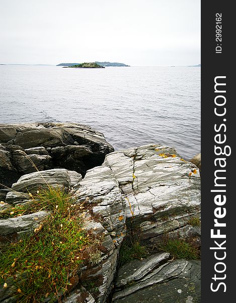 The Norwegian Sea, rocky shore and colourful plant, some small islands in the background. BEAUTY OF NORWAY COLLECTION Â». The Norwegian Sea, rocky shore and colourful plant, some small islands in the background. BEAUTY OF NORWAY COLLECTION Â»