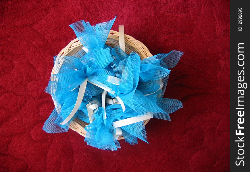Small basket full of light blue wrapping packages on a red carpet. Small basket full of light blue wrapping packages on a red carpet