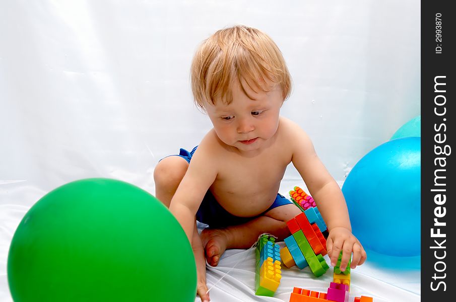 The small boy plays toys on a white background