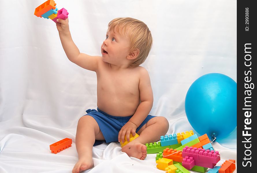 The small boy plays toys on a white background