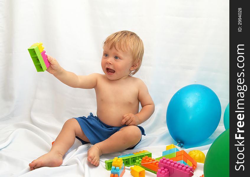 The small boy plays toys on a white background