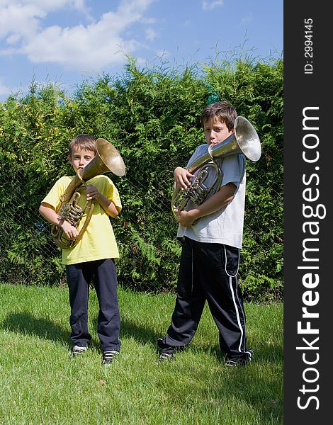 Brothers playing on the  horn in courtyard