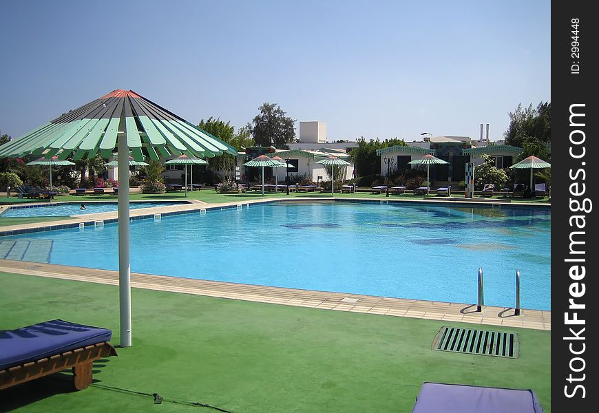 Pool in hotel. It is a lot of umbrellas. Rest.