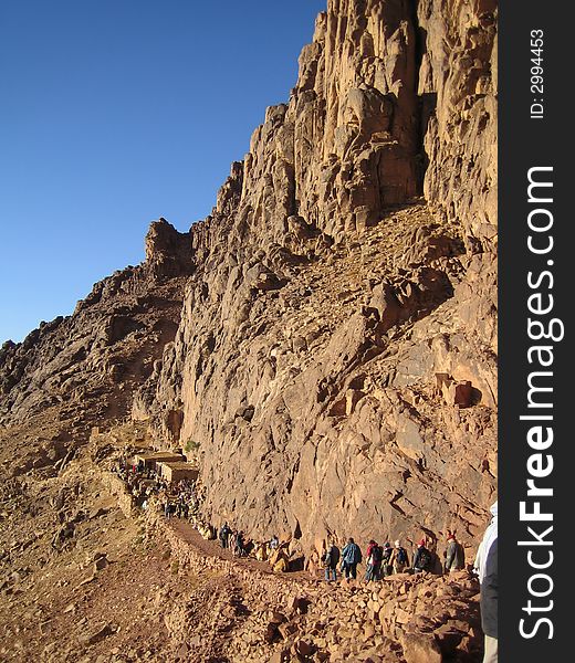 Road to mountains. The group of people rises uphill.