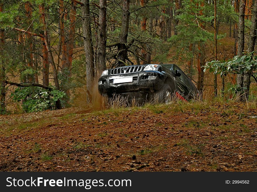 4x4 car in action in the forest. The car is going up on the hill.