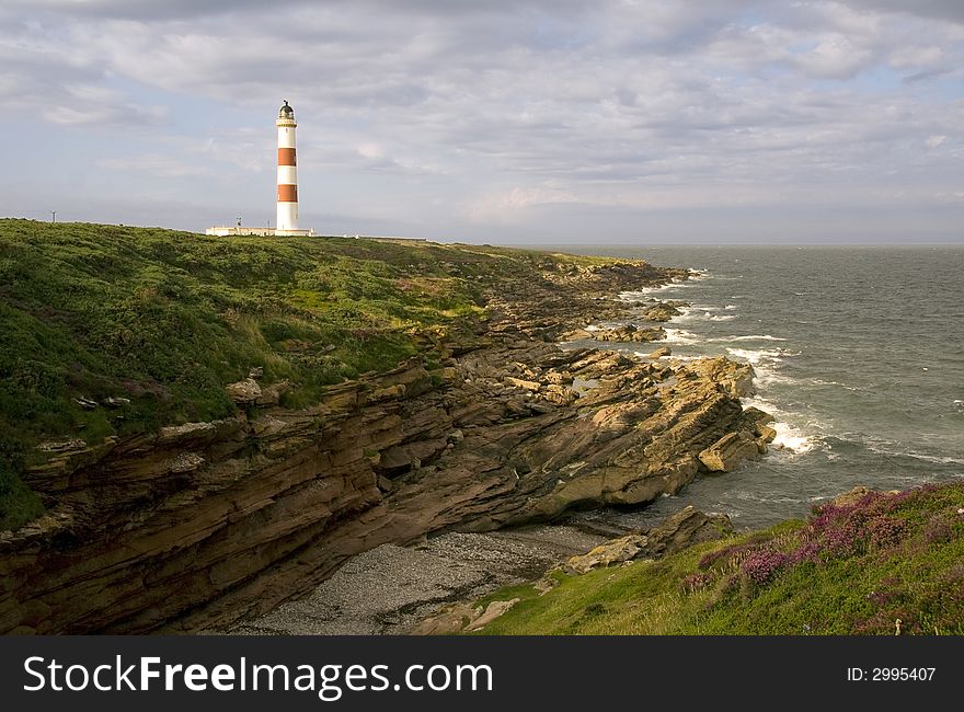 Red and white lighthouse on the cliffs overlooking the North Sea on the east coast of Scotland