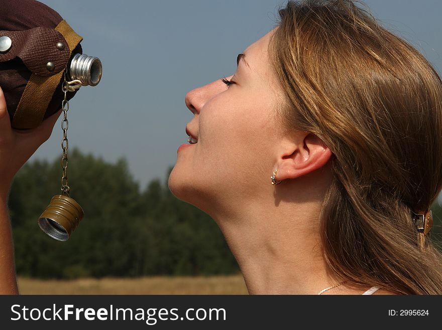 The girl quench thirst with flask in the outdoor