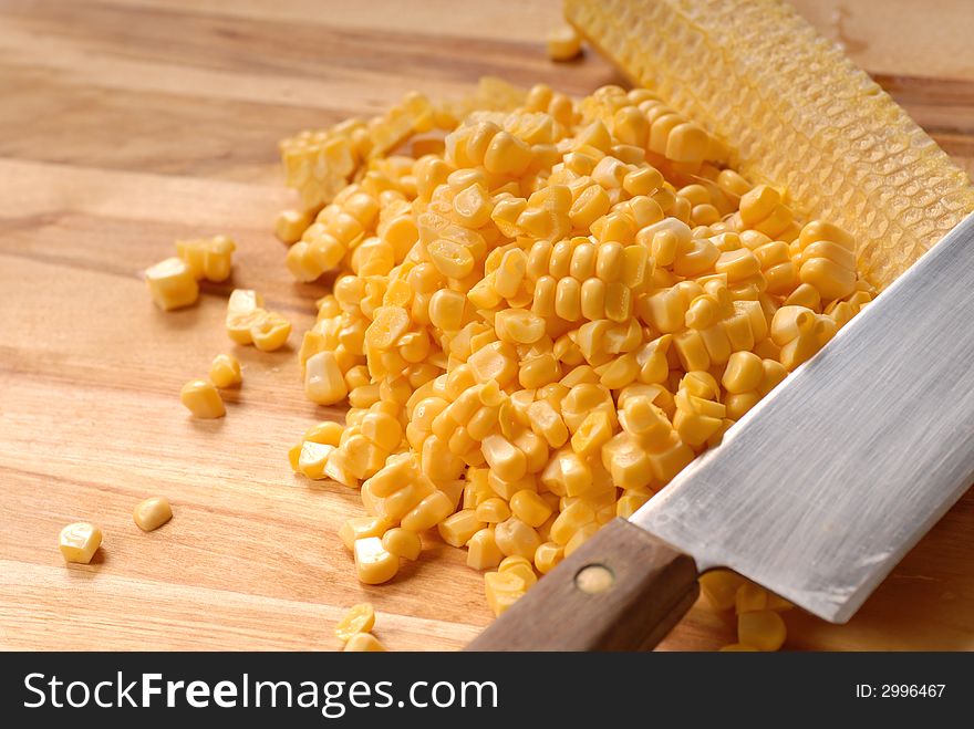 Freshly cut kernels of corn from a corn cob on a cutting board